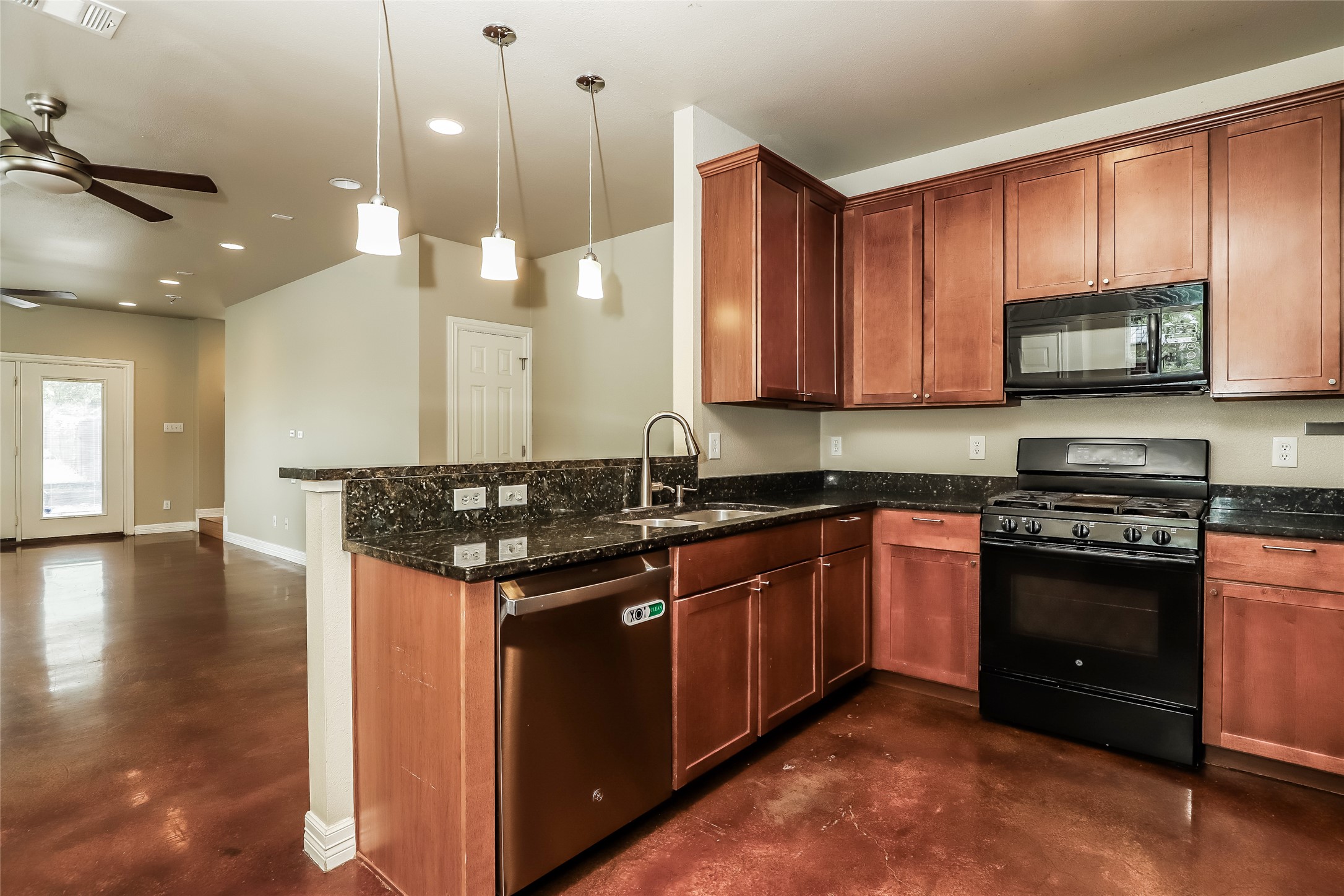 1701 Sanchez Street, Unit A Austin, TX 78702 - Photo 5 of 19 Sleek stainless steel appliances enhance the warmth of rich wood cabinetry in this modern kitchen.