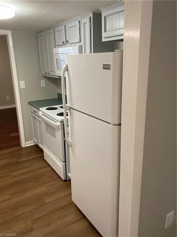 View from front of kitchen, looking right, shows a spotlessly clean fridge (which is included in the sale).