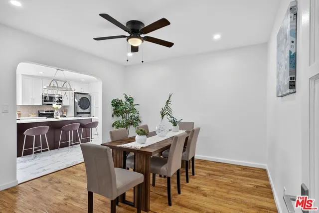 a kitchen with stainless steel appliances a dining table and chairs