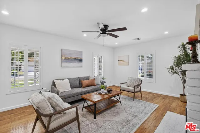 a kitchen with stainless steel appliances a sink a stove a refrigerator cabinets and a dining table