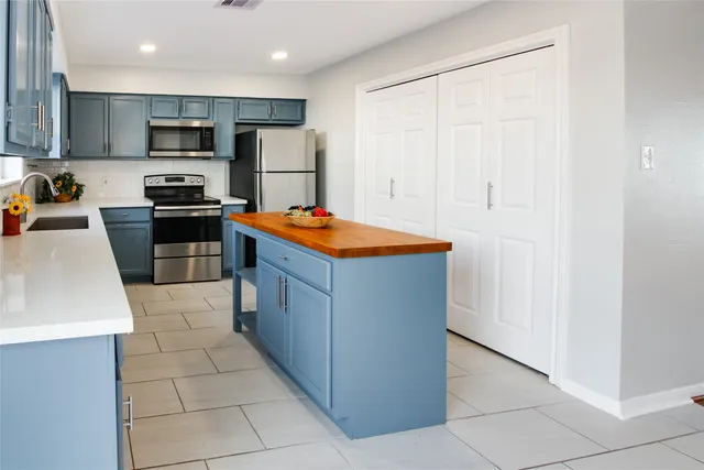 a kitchen with stainless steel appliances granite countertop a refrigerator and a stove