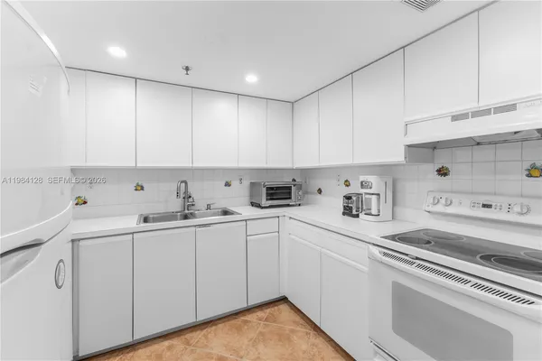 a kitchen with cabinets and chairs
