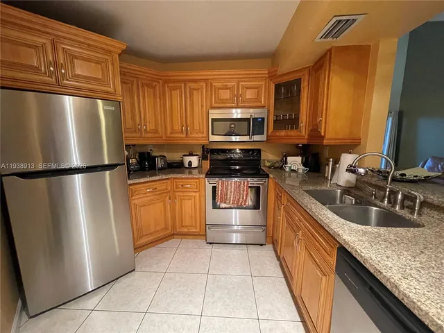 a kitchen with stainless steel appliances granite countertop a sink stove and microwave