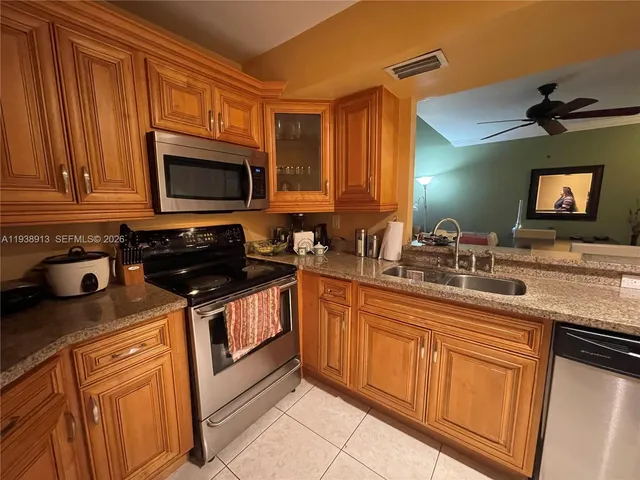 a living room with furniture a flat screen tv and kitchen view