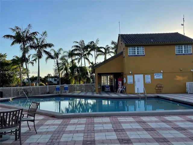 a view of a patio with table and chairs with wooden floor and plants