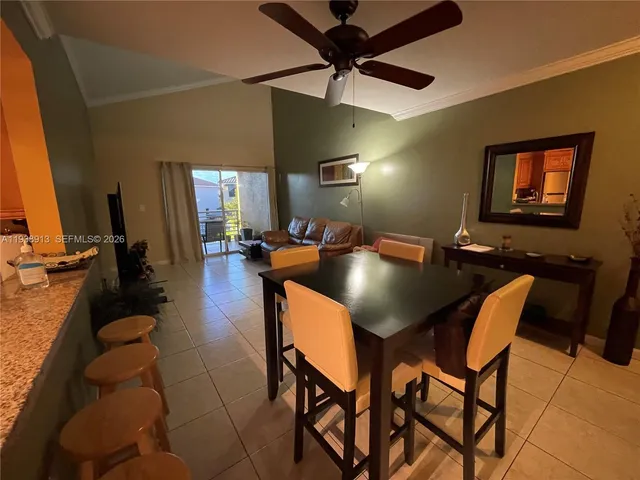 a living room with furniture a dining table and a potted plant