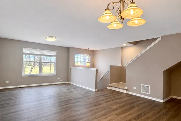 a view of empty room with window and wooden floor