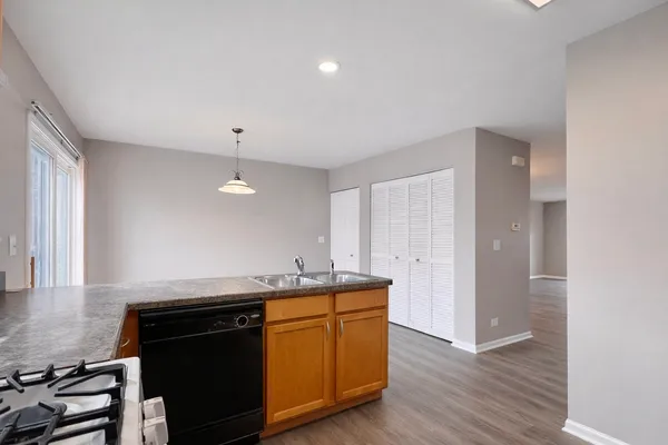 a kitchen with a sink and a stove top oven with wooden floor