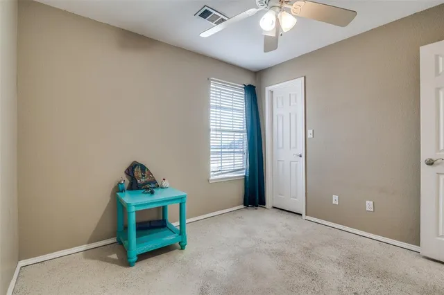an empty room with a cabinet and a fan
