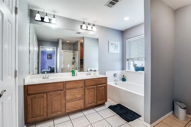 a spacious bathroom with a double vanity sink a mirror and a