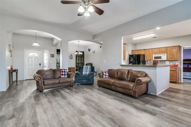 a living room with furniture ceiling fan and a window