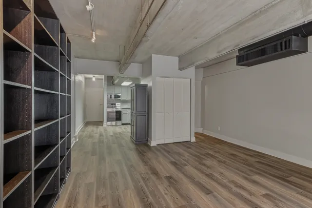 a view of an empty room with wooden floor