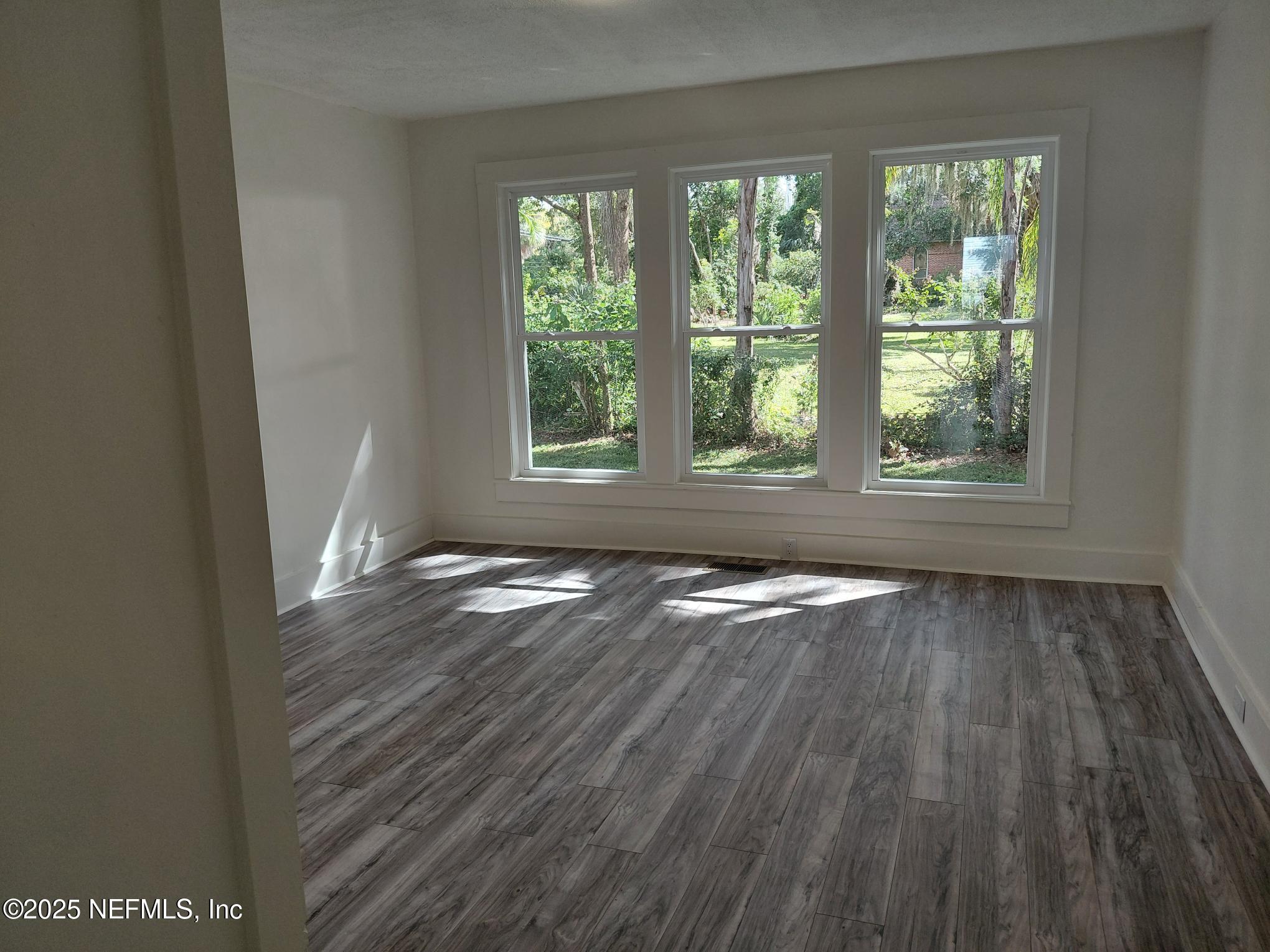 232 South Main Street Crescent City, FL 32112 - Photo 11 of 24 an empty room with wooden floor and windows