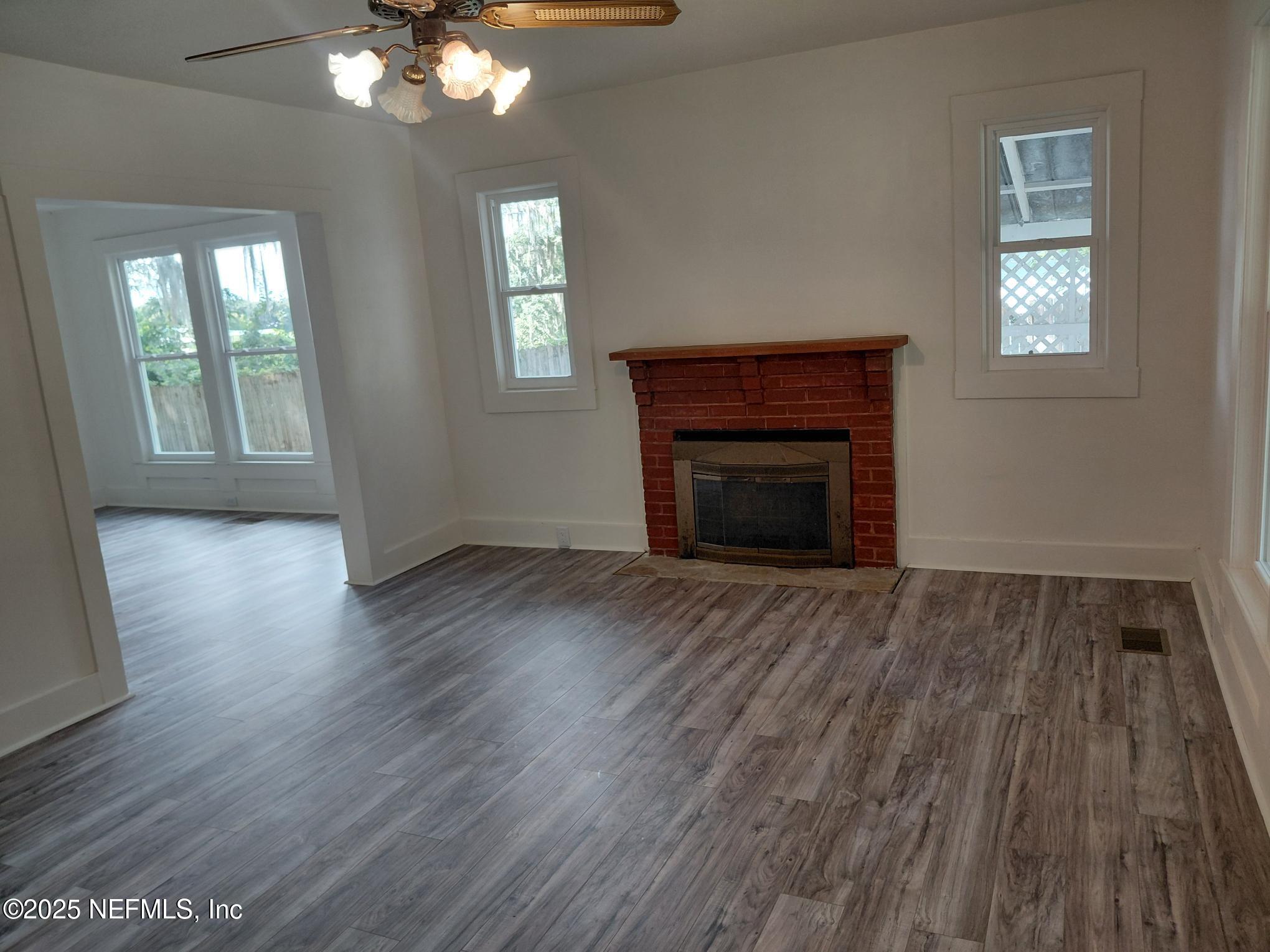 232 South Main Street Crescent City, FL 32112 - Photo 9 of 24 a view of an empty room with wooden floor and a window