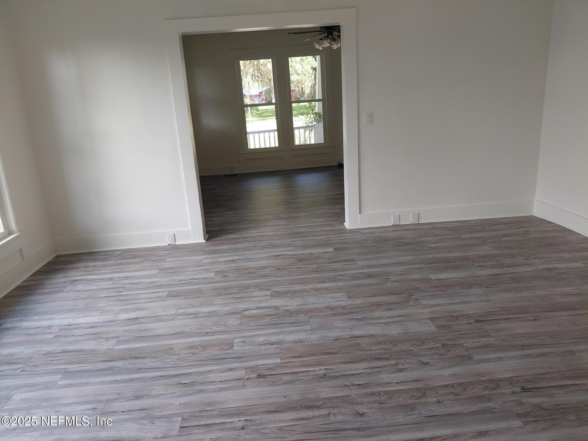 232 South Main Street Crescent City, FL 32112 - Photo 10 of 24 a view of an empty room with wooden floor and a window
