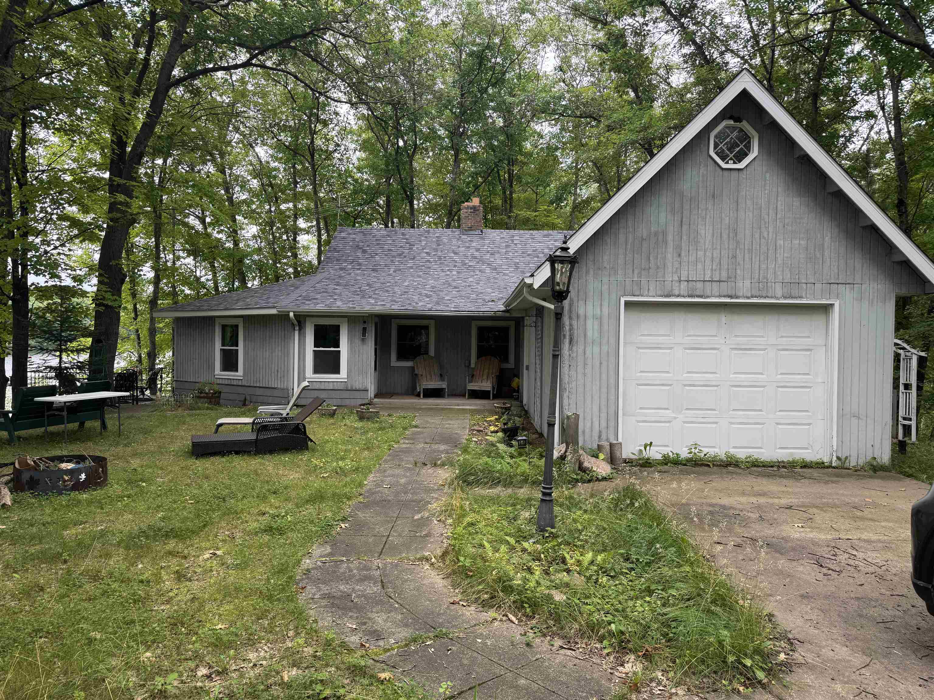 10570 Eagle Lake Road Delta, WI 54847 - Photo 2 of 24 View of front facade with covered porch, a garage, view of wooded area, and driveway