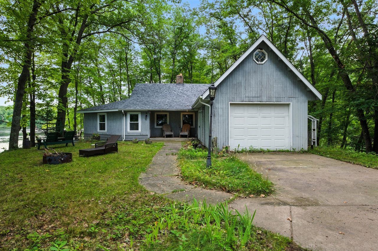 10570 Eagle Lake Road Delta, WI 54847 - Photo 23 of 24 View of front of house with a porch, a garage, driveway, a chimney, and a front yard