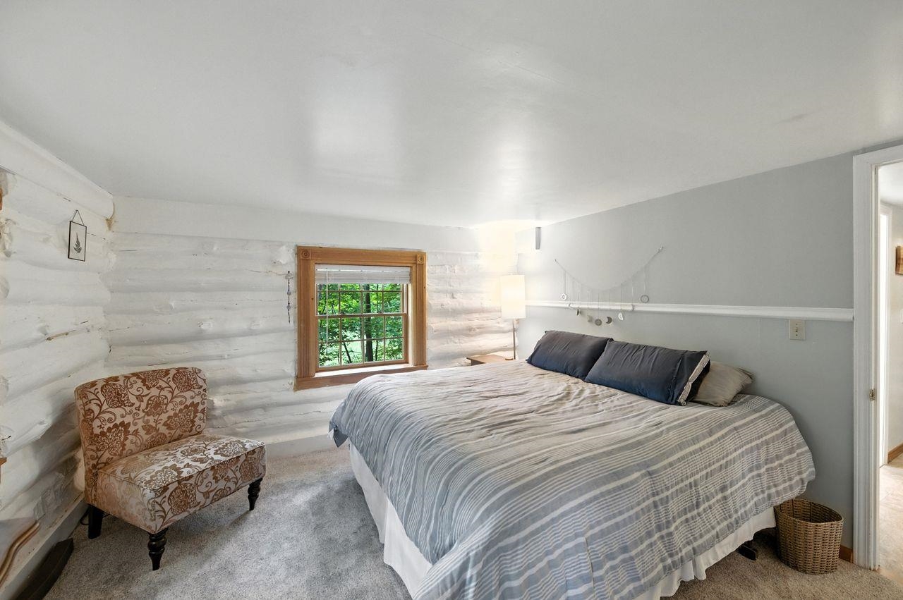 10570 Eagle Lake Road Delta, WI 54847 - Photo 8 of 24 Carpeted bedroom featuring rustic walls