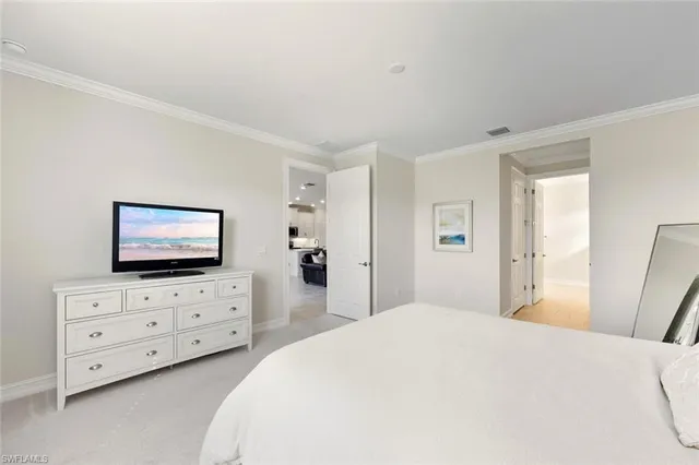 a kitchen that has a lot of white cabinets and stainless steel appliances