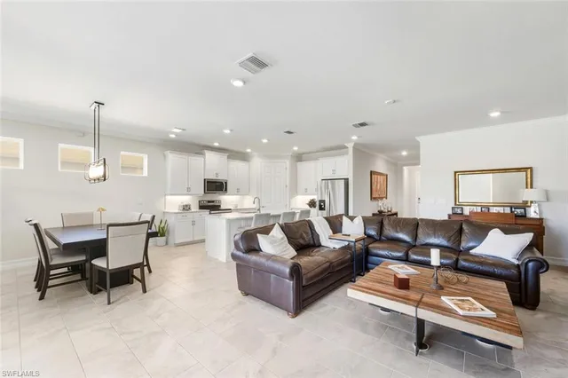 a living room with furniture and a dining table with kitchen view