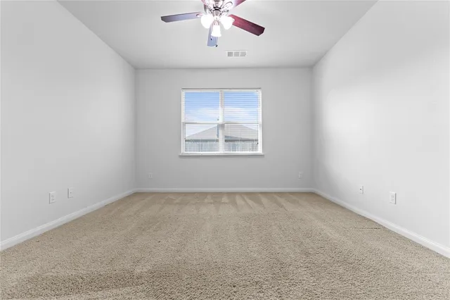 an empty room with a window and a ceiling fan