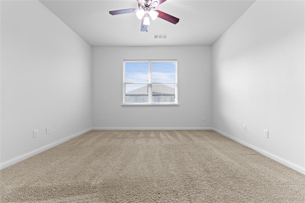 1815 Hot Springs Way Princeton, TX 75407 - Photo 18 of 22 an empty room with a window and a ceiling fan