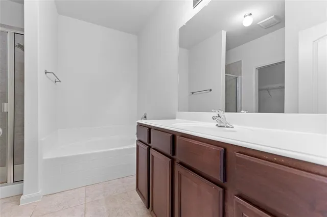 a bathroom with a tub sink and mirror