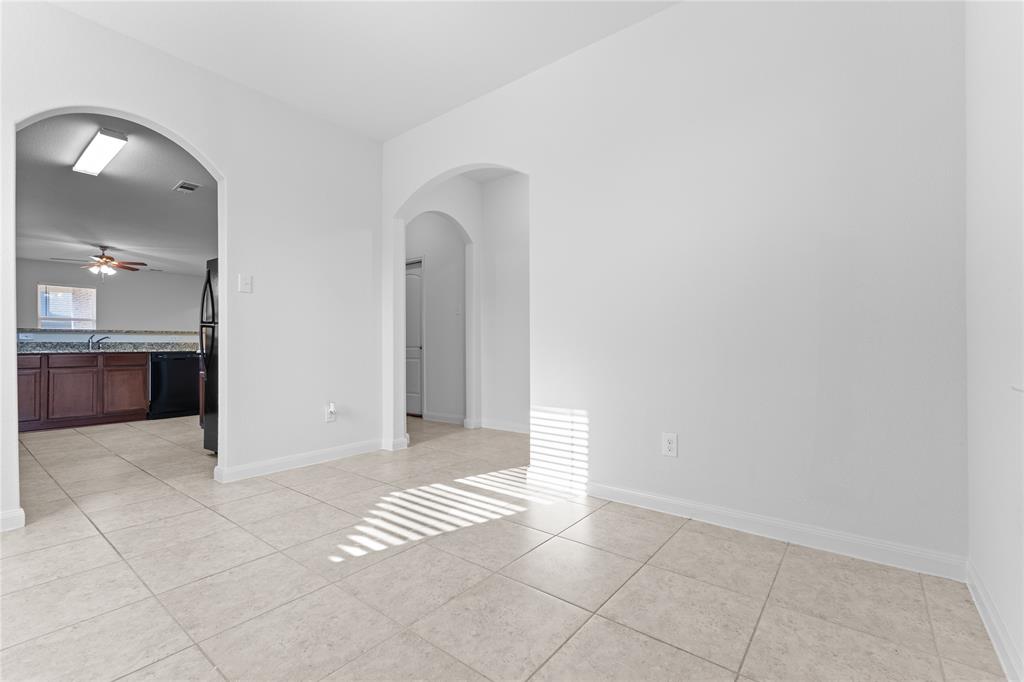 1815 Hot Springs Way Princeton, TX 75407 - Photo 4 of 22 an empty room with kitchen and mirror