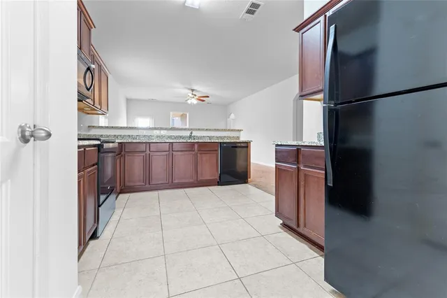 a kitchen with stainless steel appliances granite countertop a refrigerator and a stove