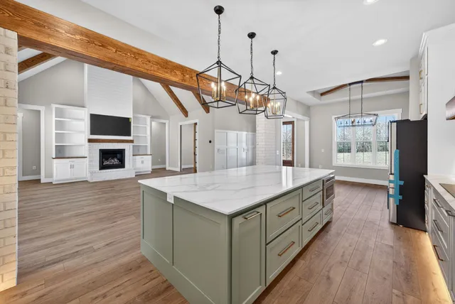 an empty room with wooden floor cabinet and windows