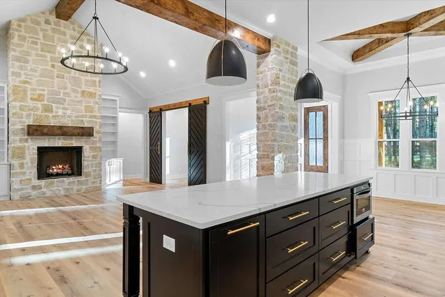 a view of a livingroom with wooden floor and a kitchen space