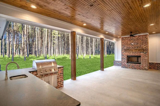a view of an empty room with wooden floor fireplace and a window