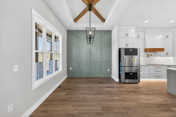 a kitchen with stainless steel appliances granite countertop a kitchen island a stove and a wooden floors