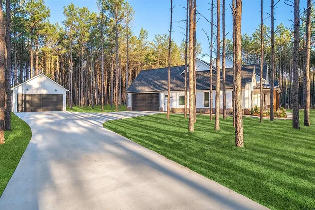 a backyard of a house with lots of green space and fountain
