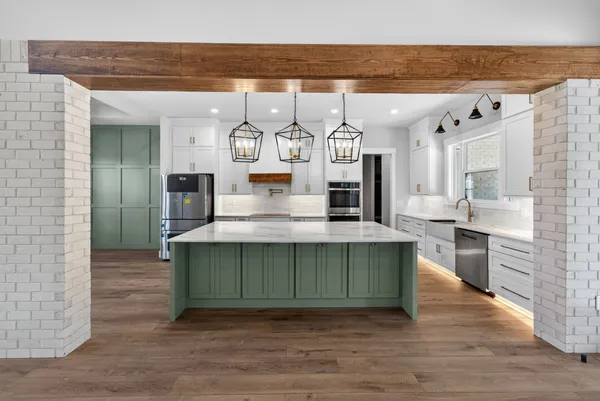a kitchen with stainless steel appliances granite countertop a sink dishwasher and a stove with wooden floor