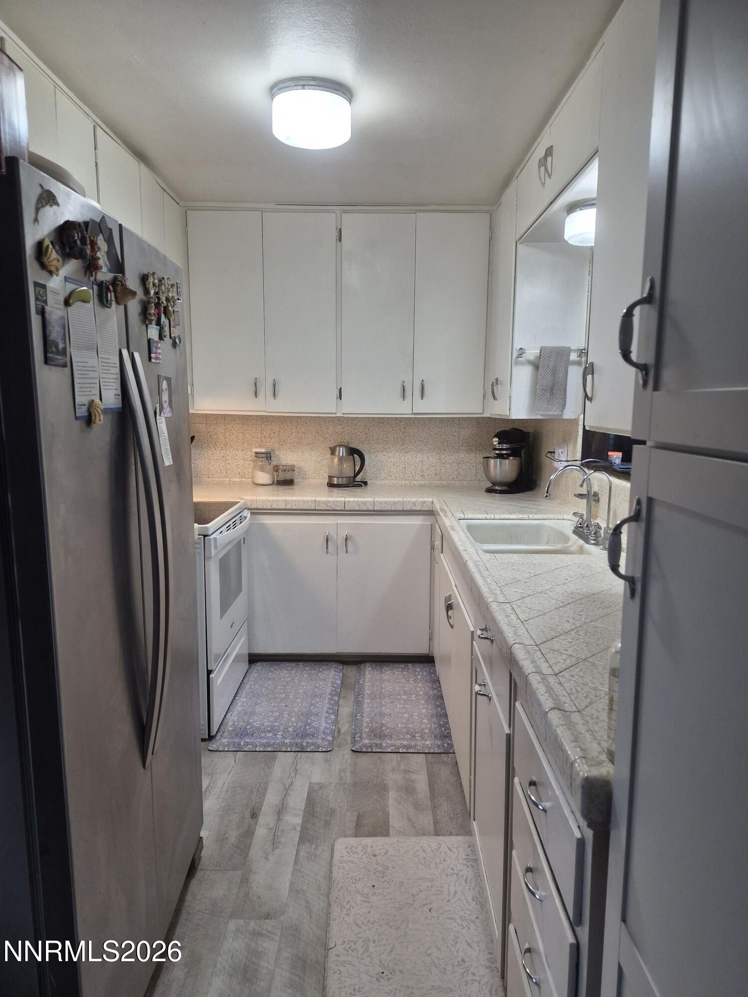 3280 Lone Tree Road Fallon, NV 89406 - Photo 39 of 59 a kitchen with a sink a refrigerator and cabinets