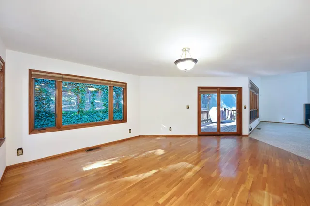 a view of a backyard with large trees and wooden fence