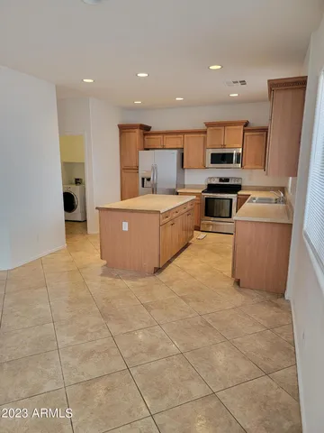 a large kitchen with stainless steel appliances a sink a counter top space cabinets and a window