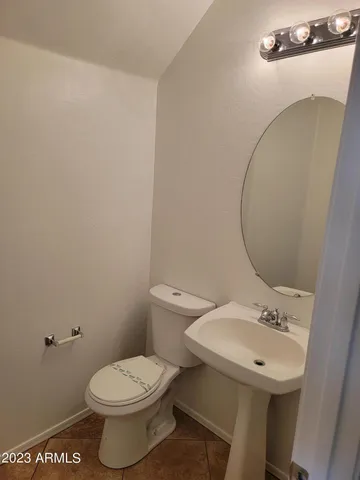 a bathroom with a sink mirror and toilet
