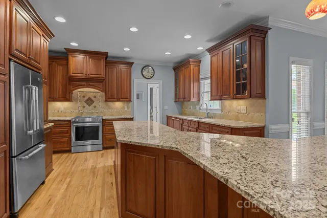 a kitchen with stainless steel appliances granite countertop wooden cabinets and granite counter tops