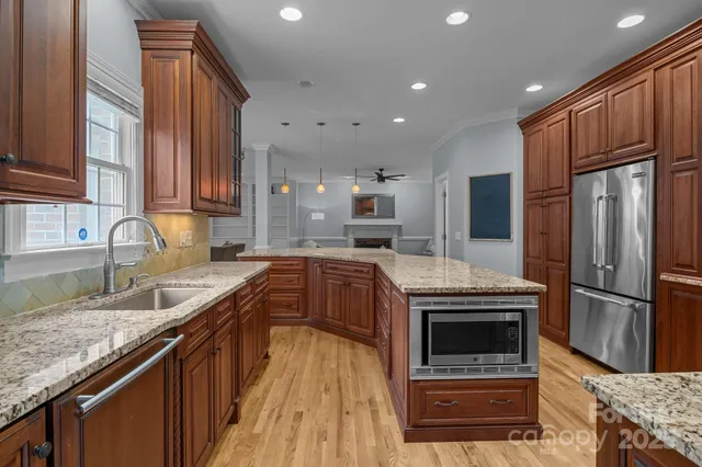 a kitchen with stainless steel appliances granite countertop a sink stove and refrigerator