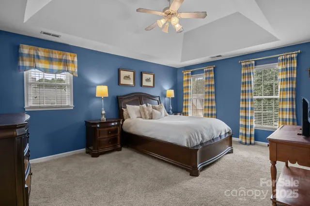a spacious bedroom with a bed and a chandelier