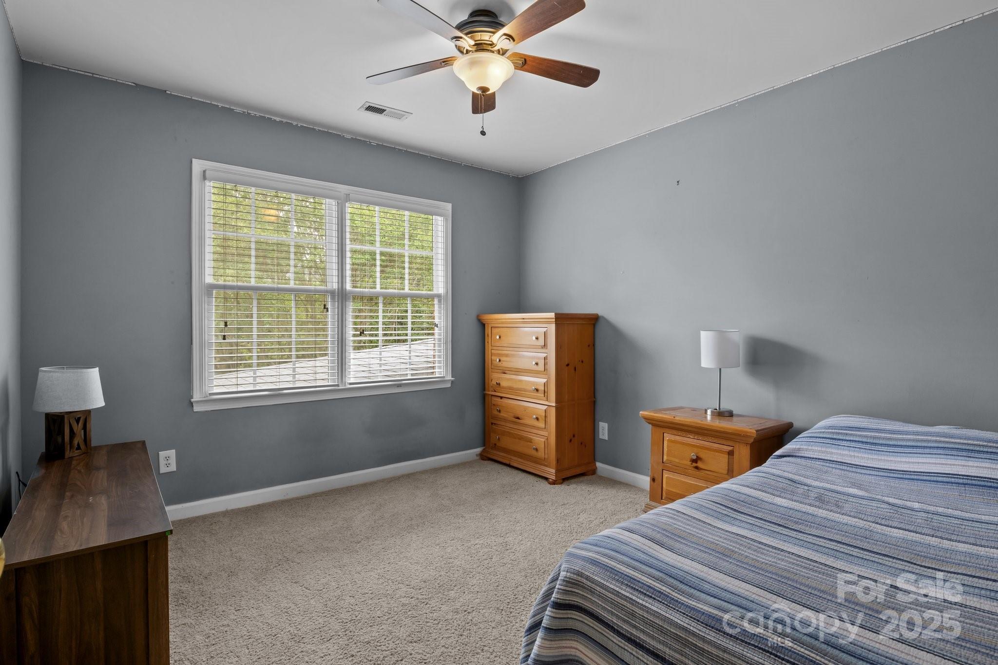 9717 Waterton Court Huntersville, NC 28078 - Photo 26 of 47 a bedroom with a bed and a chandelier