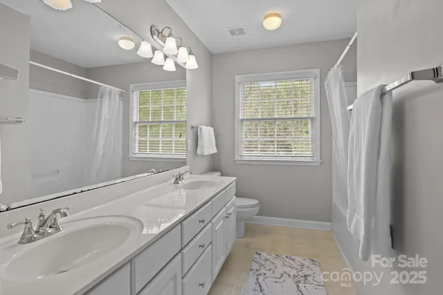 a spacious bathroom with double vanity and a mirror