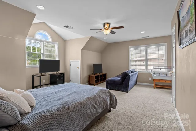a spacious bedroom with a bed a couch and dresser