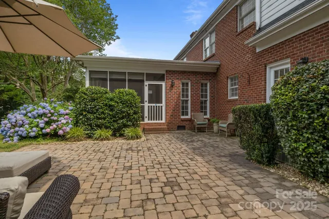 a front view of a house with a yard and potted plants