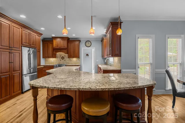a kitchen with stainless steel appliances granite countertop a kitchen island a table and chairs