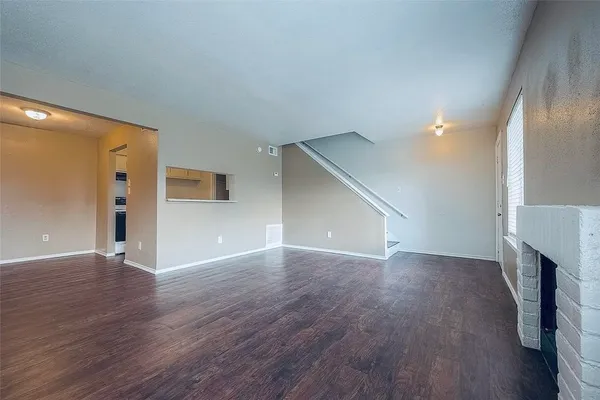 a view of a livingroom with wooden floor and a fireplace