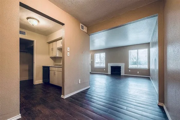 a view of a living room with hardwood floor and a kitchen