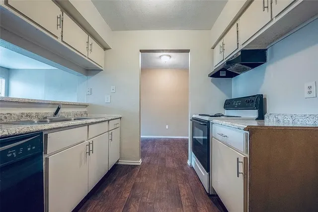 a kitchen with granite countertop a sink and a stove top oven